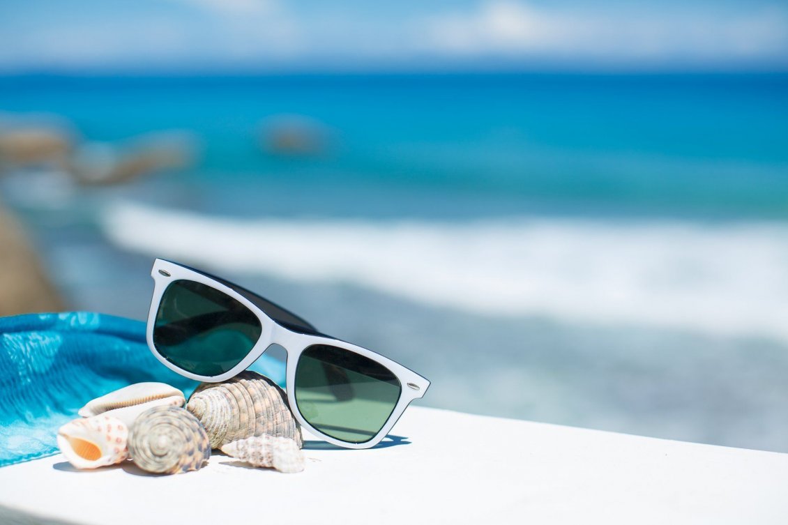 Download Wallpaper Sunglasses and shells -Wonderful blurry ocean on background