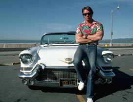 Arnold Schwarzenegger sit on a white car