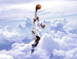 Basketball player with his ball in the air above the clouds