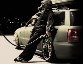 Man with gas mask getting gas at a gas station