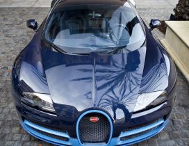 Blue Bugatti Veyron front view on sidewalk