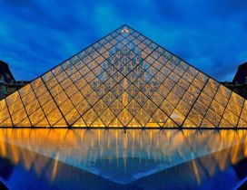 Louvre museum pyramid lighted in night