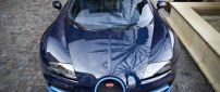 Blue Bugatti Veyron front view on sidewalk