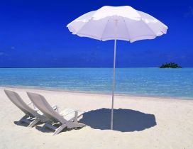 Two white sunbed and an umbrella - summer time
