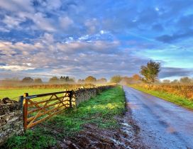 Sunrise over the country side road and fence