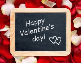 Happy Valentine's Day write on a blackboard - rose petals