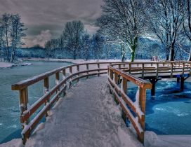 Wonderful frozen bridge over a frozen lake with blue water