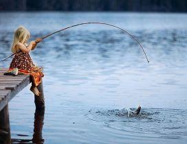 Little blonde girl fishing in a lake - Wonderful photo