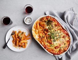 Delicious pasta at the oven with tomatoes, cheese parsley