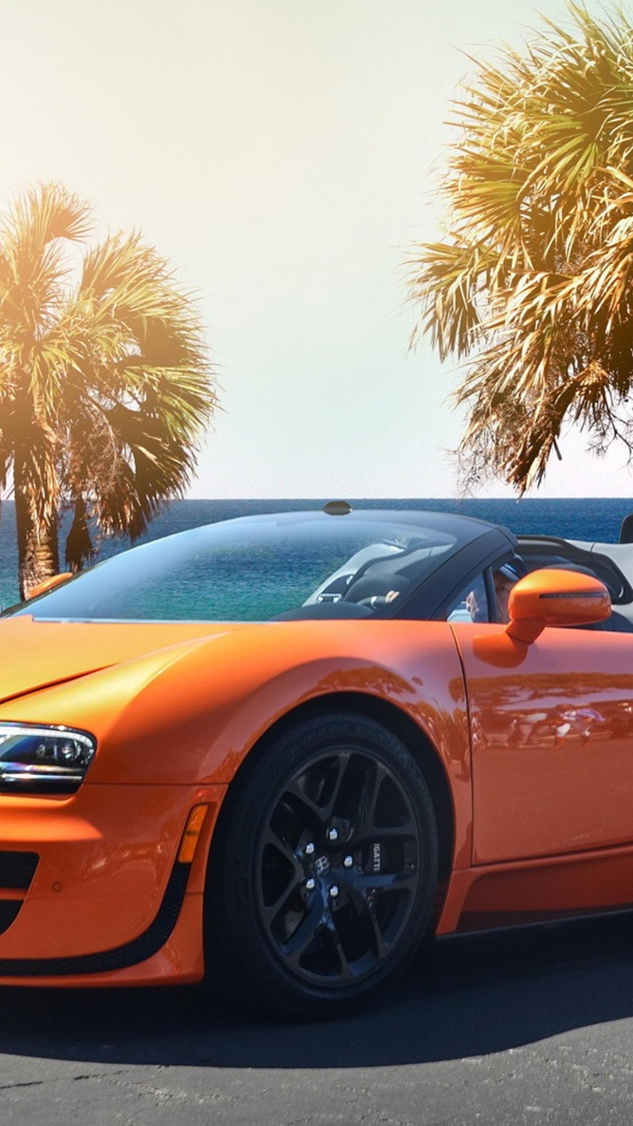 Gorgeous orange Bugatti Veyron w16 on the shore of sea