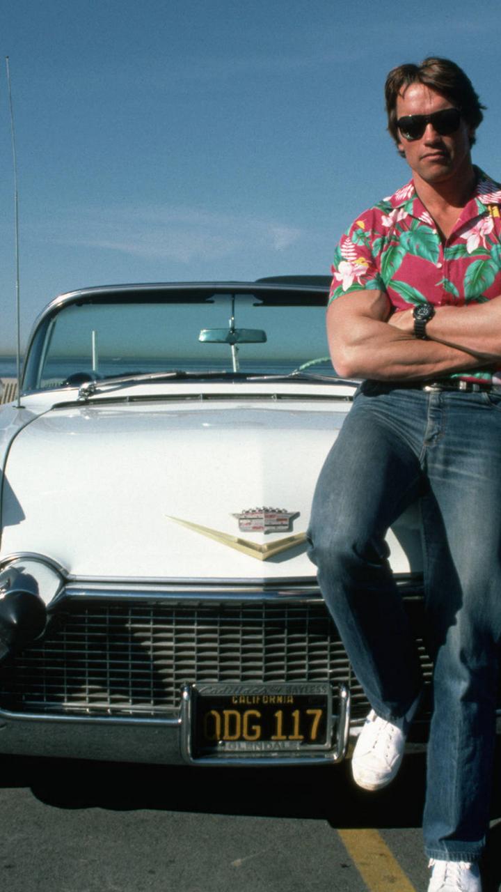 Arnold Schwarzenegger sit on a white car