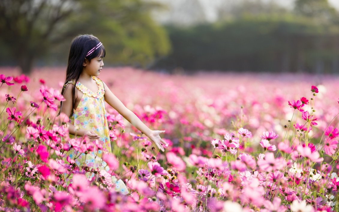 Download Wallpaper Little girl walking through a field full of pink flowers
