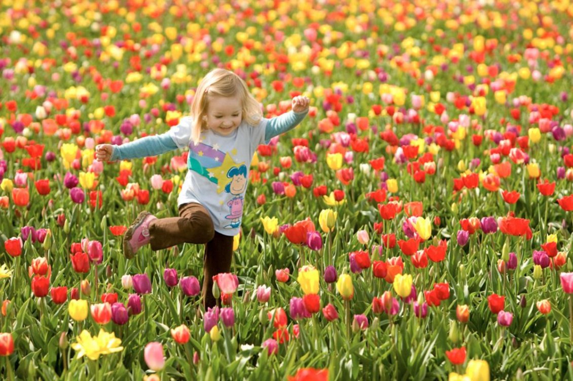 Download Wallpaper A happy girl in a field with colorful tulips