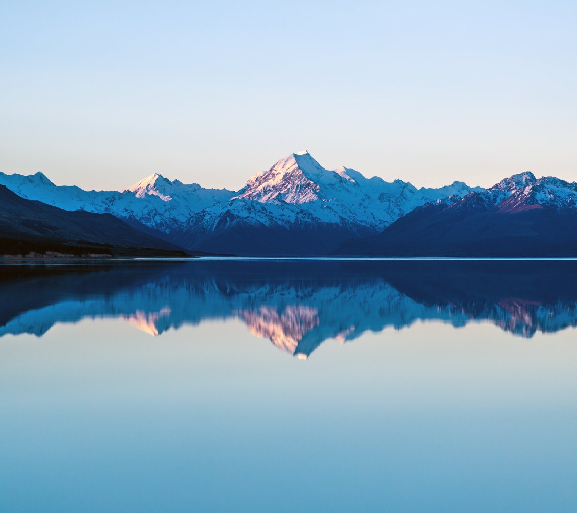 Download Wallpaper Mountain peaks reflected in the lake water
