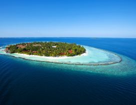 Island in the middle of the sea. Blue water and blue sky