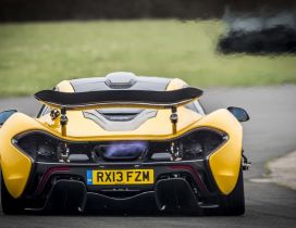 Yellow McLaren P1 exhaust flames
