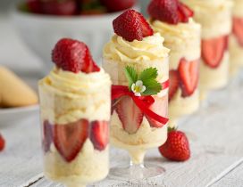 Several glasses with dessert of vanilla and strawberries