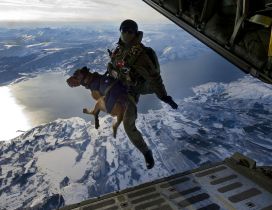 Soldier jumps from an airplane with a dog in her arms