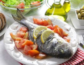 Fish with lemon, tomatoes and salad