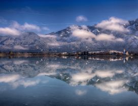 The city and mountains reflected in the lake waters