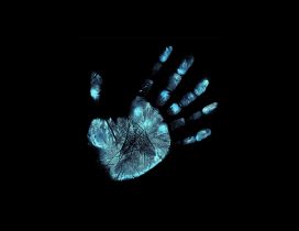 Blue footprint of hand on black background