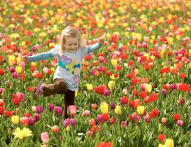 A happy girl in a field with colorful tulips