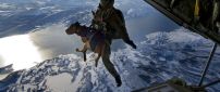 Soldier jumps from an airplane with a dog in her arms