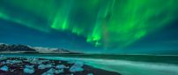 Green aurora borealis over the ocean