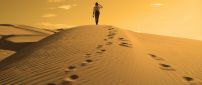 One man and his traces in the sand of desert
