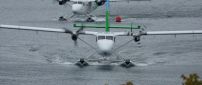 Two white and green seaplanes on the water