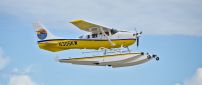 White and yellow seaplanes flying in the air