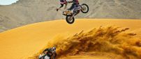 Two men with motocross in desert