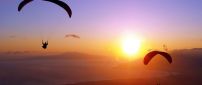 Two paratroopers flying in the sunset