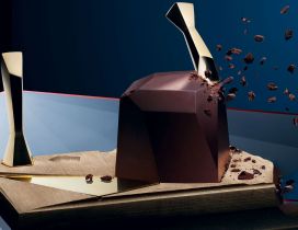 Chocolate shards falling from a big chocolate cube