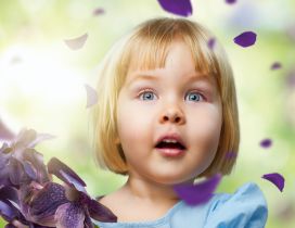 A sweet blonde girl between many purple petals
