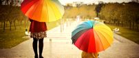 Two women with colorful umbrellas in the rain