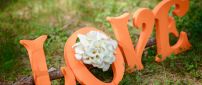 Orange love letters on a wood in the grass