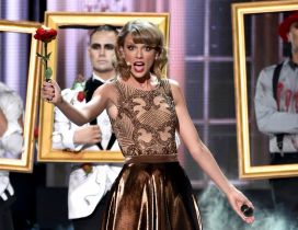 Taylor Swift sings on scene with a red rose in hand
