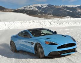 Blue Aston Martin Vanquish on snow