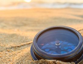 A compass in the sand on beach