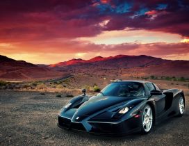 Black Enzo Ferrari in mountains in sunset