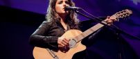 Katie Melua sings with a guitar on a scene