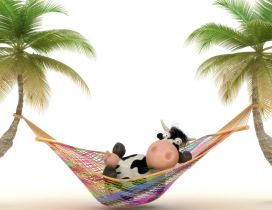 A cow relaxing in a colorful hammock