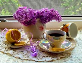 Lilac flowers and a delicious cup of tea with lemon