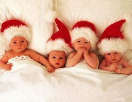 Four sweet little babies with Christmas hat