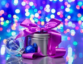 Purple ribbon on a Christmas gift - Lights on background