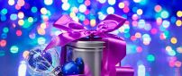 Purple ribbon on a Christmas gift - Lights on background