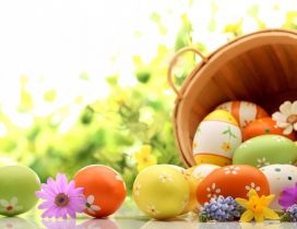Wooden basket full with Easter eggs - Spring colours