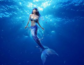 Beautiful blue mermaid in the middle of the ocean water