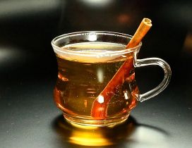 Cinnamon stick in a cup of hot fruit tea